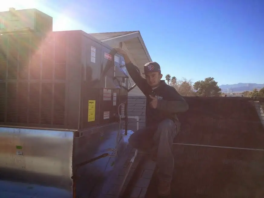 HVAC technician performing Boiler Repair on a rooftop unit in Mantua